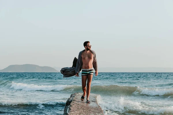 サンセットのビーチでバスローブ姿の若い男 — ストック写真