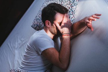 Genç adam yatakta sabah uyanma yorgun