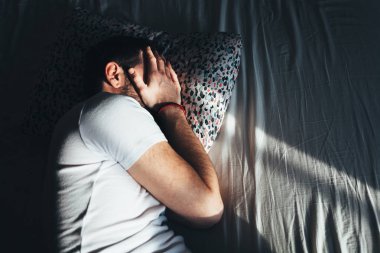 Yatakta ağlayan genç depresif adam