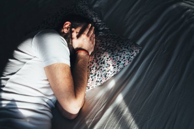 Yatakta ağlayan genç depresif adam