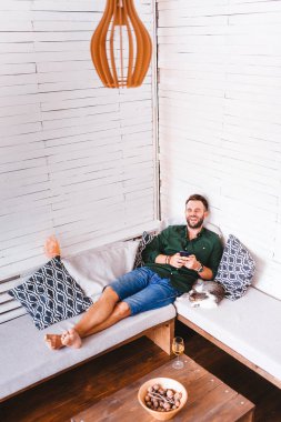 Oturma odasında Smartphone kullanan genç adam