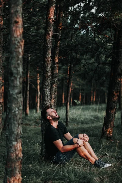 独自坐在森林里的沮丧的年轻人 — 图库照片