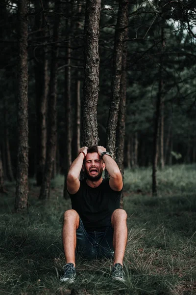 独自坐在森林里的沮丧的年轻人 — 图库照片