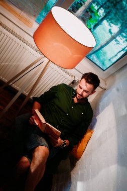 Pencere kenarındaki evde kitap okurken erkek