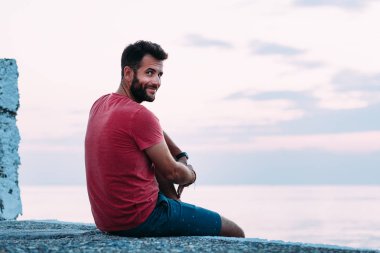 Genç adam mavi saat denizin tadını çıkarıyor.