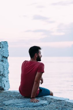 Genç adam mavi saat denizin tadını çıkarıyor.