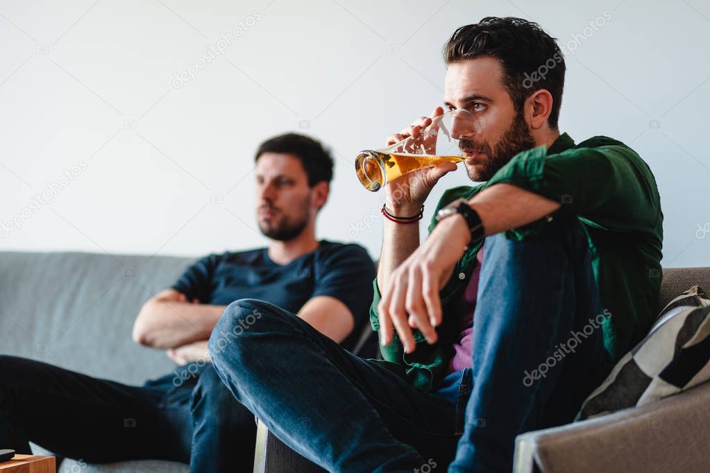 Two guys watching football match on TV