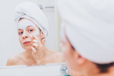 Genç kadın bir maske onun yüzüne koydu