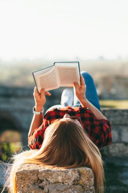 Genç kadının kamu parki bir kitap okuma