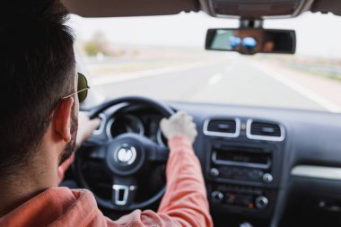 Young man driving a car, interior shot