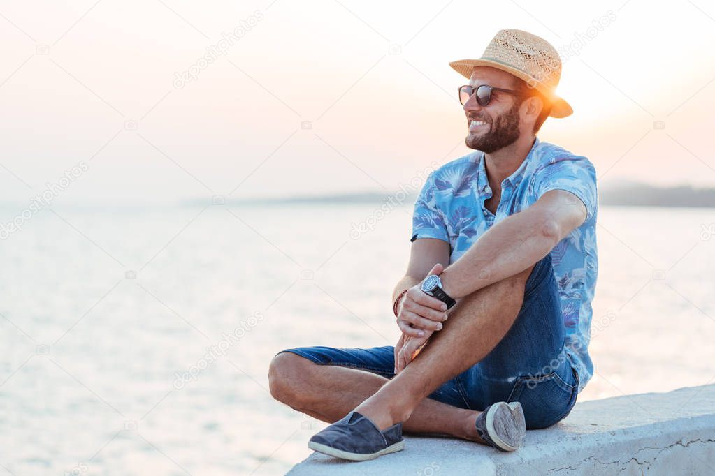 Young man enjoying sunset by the sea