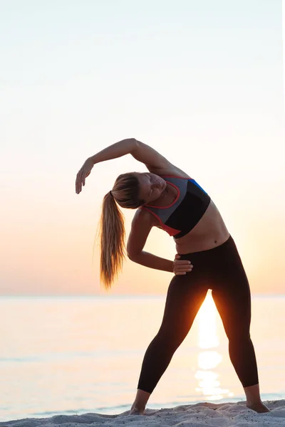 Giovane Donna Spiaggia Tramonto Che Estende Dopo Allenamento — Foto Stock