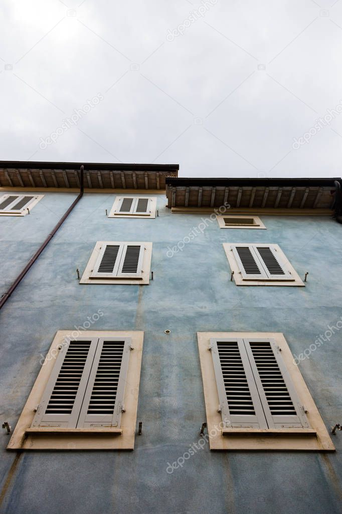 Low angle view of the windows on the old building in San Quirico in Tuscany, Italy