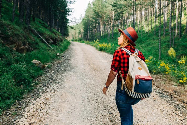 山岳未舗装道路を歩く若い女性自然探検家 — ストック写真