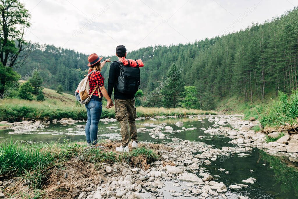 Young couple exploring nature by the mountain river