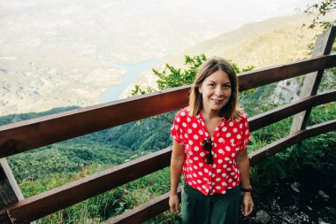 Genç kadın doğa kaşifi dağ manzarasının tadını çıkarıyor.