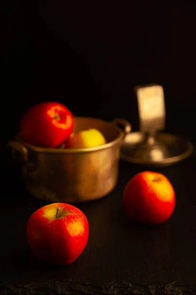 Red apples and kitchen stuff on black shale board. Low key. — Stock Image Red Apples Kitchen Stuff Black Shale Board Low Key Stock Picture