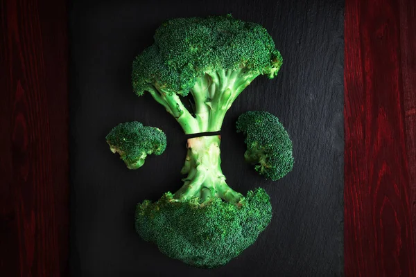 Siyah şist tahtasında brokoli, düz. Alçak tuş.