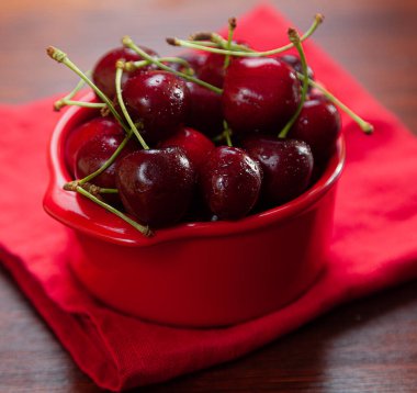 Sağlıklı kahvaltı, yulaf ezmesi, tatlı kiraz, kırmızı peçeteyle servis edilen çay ve süt, beyaz arka planda.. 