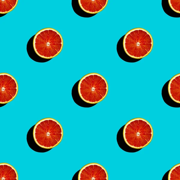 Turkuaz arka planda taze kan kırmızı turuncu turunçgil meyvesinin kusursuz görüntüsü. Sert ışık. 