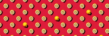 Canlı kırmızı arka planda pürüzsüz desenlere karşı taze limon yarıları. Üst Manzara. Pankart. Sert ışık.