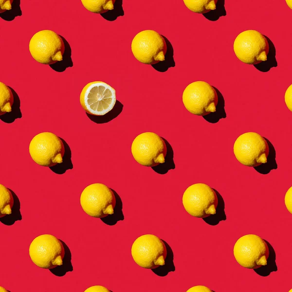 Canlı kırmızı arkaplanlı, pürüzsüz desenli, taze limonlar. Üst Manzara. Sert ışık.