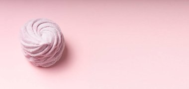 Pembe arka plana karşı bir tatlı pembe marşmelov. Yumuşak ışık. Boşluğu kopyala.