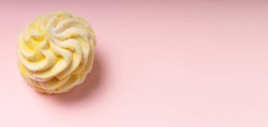 Pembe arka plana karşı bir tatlı sarı marşmelov. Yumuşak ışık. Boşluğu kopyala.