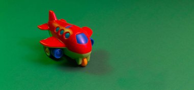 Yeşil arka planda renkli oyuncak jet uçakları olan yaratıcı bir kavram. Parlak renklendirme. Pankart. Boşluğu kopyala.