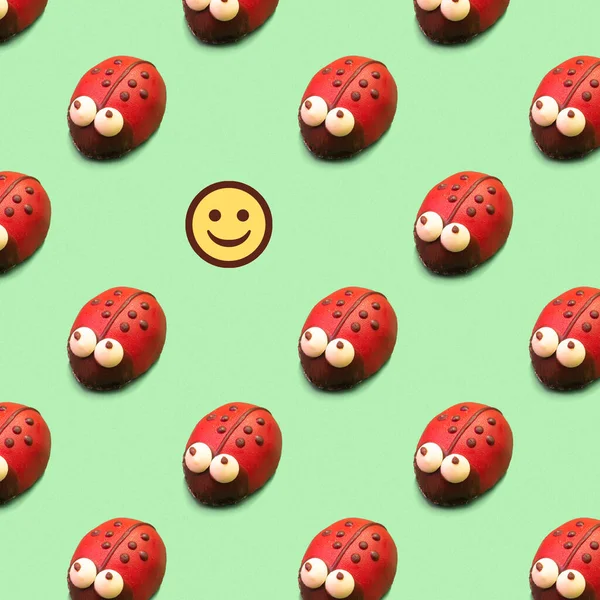 Çocukların doğum günü partisi ve Uğurböceği ile tatil konsepti. Lezzetli, renkli, yeşil arka planda dikişsiz pasta deseni. Süslü bir pastanın yerini Smiley alır.. 