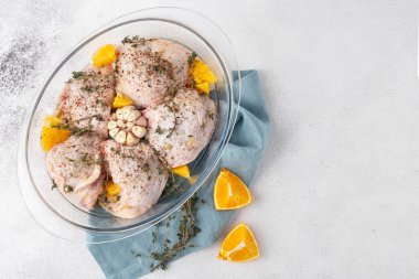 Salamura edilmiş çiğ tavuk butları ve portakallı kekik sarımsağı sıcağa dayanıklı üst manzara.