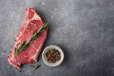 Biberiye ve biberiyeli çiğ biftek, arka planda koyu bir üst manzara.