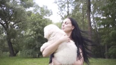 Güzel kız bir köpek yavrusu ve doğada büyük bir köpekle oynuyor.