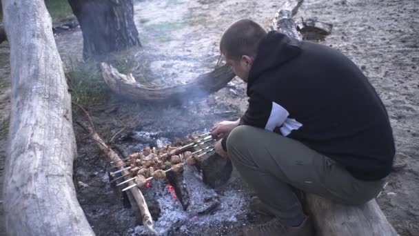 Knappe Vent Kookt Vleesspiesjes Een Vuur Het Bos — Stockvideo