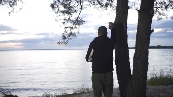 Yakışıklı Adam Ormanda Nehrin Kenarında Duruyor Gün Batımını Seyrediyor — Stok video