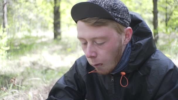 英俊的里加男人带着雀斑在森林里吃烤面包 — 图库视频影像