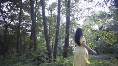 Güzel kız gün batımında gölün yanındaki ormanda yürür.