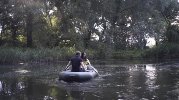 Egy Jóképű Srác Egy Gyönyörű Lány Úszik Egy Gumicsónakban Tavon — Stock videók