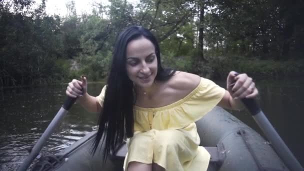 美しい少女は夜に湖のゴムボートに乗って泳ぎ — ストック動画