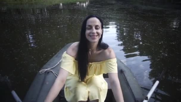 美しい少女は夜に湖のゴムボートに乗って泳ぎ — ストック動画