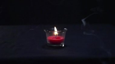 Güzel bir mum yanar ve su damlası onu yavaş çekimde söndürür.