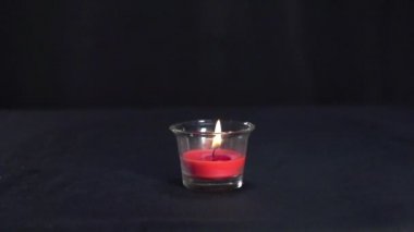 Güzel bir mum yanar ve su damlası onu yavaş çekimde söndürür.