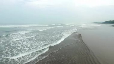 Plajın güzel hava manzarası Tropikal ormanın siyah kumlarıyla