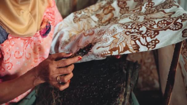 Close up old woman painting batik with canting — Stock Video