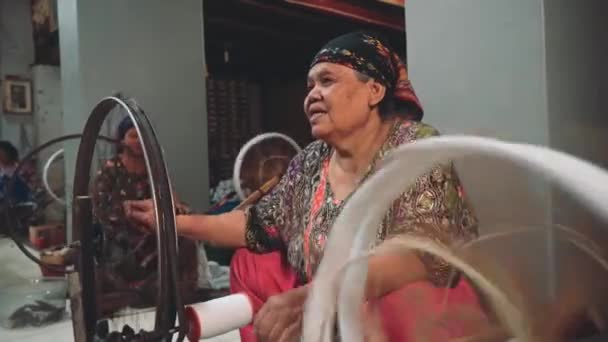 Indonesische vrouw met behulp van spinnewiel — Stockvideo