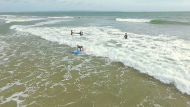 Kadın sığ sularda sörf öğrenme