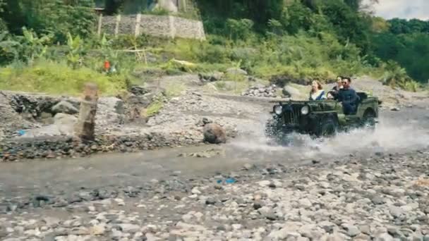 Two woman and man driving jeep in river — Stock Video