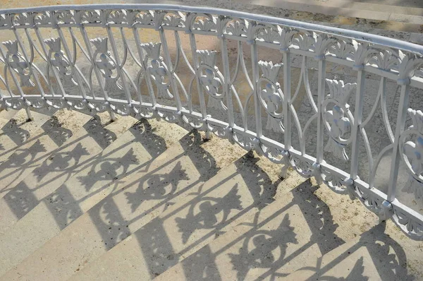 Stairs with beautiful wrought iron railings that cast a shadow.Catherine park. Russia.