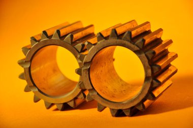 Sarı arka planda metal dişliler. Arabanın bir parçası.