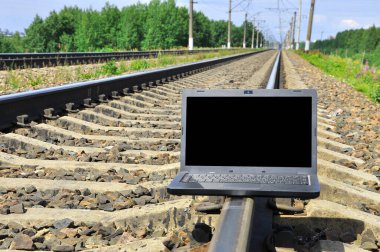 Tren raylarında siyah dizüstü bilgisayar. Turizm sektörü.
